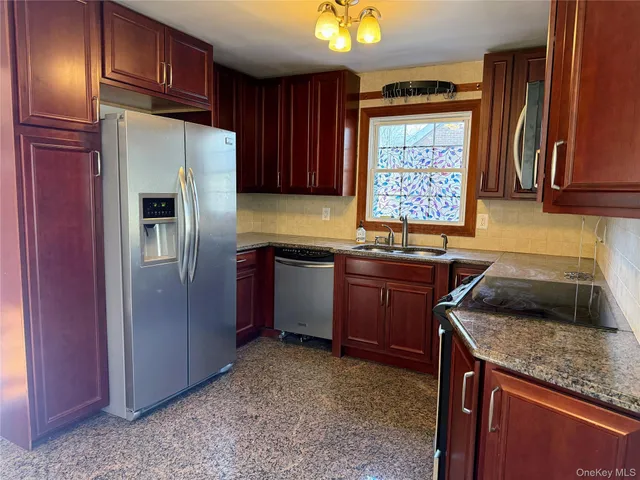 a large kitchen with a refrigerator a stove top oven a sink and dishwasher