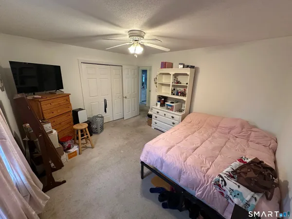 a bedroom with a bed a couch and flat screen tv