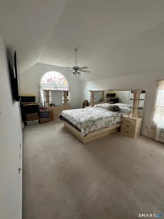 a spacious bedroom with a bed and a chandelier