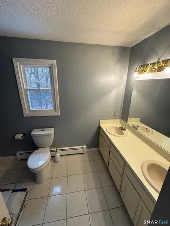 a bathroom with a toilet sink and mirror