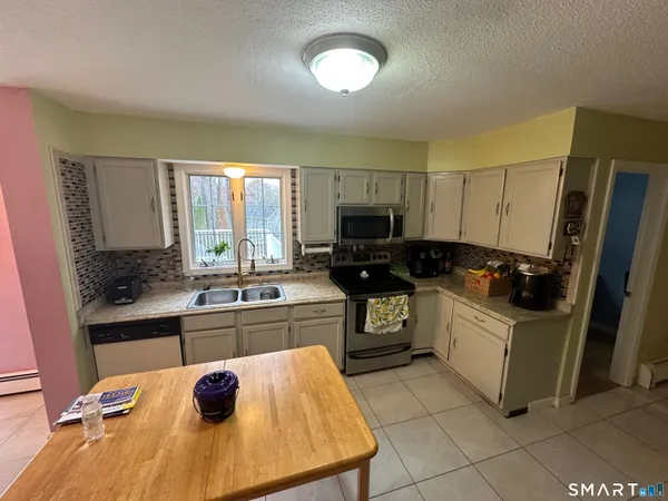 a kitchen with a sink a stove top oven and cabinetry