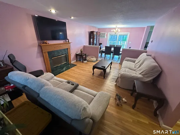 a living room with furniture a flat screen tv and kitchen view