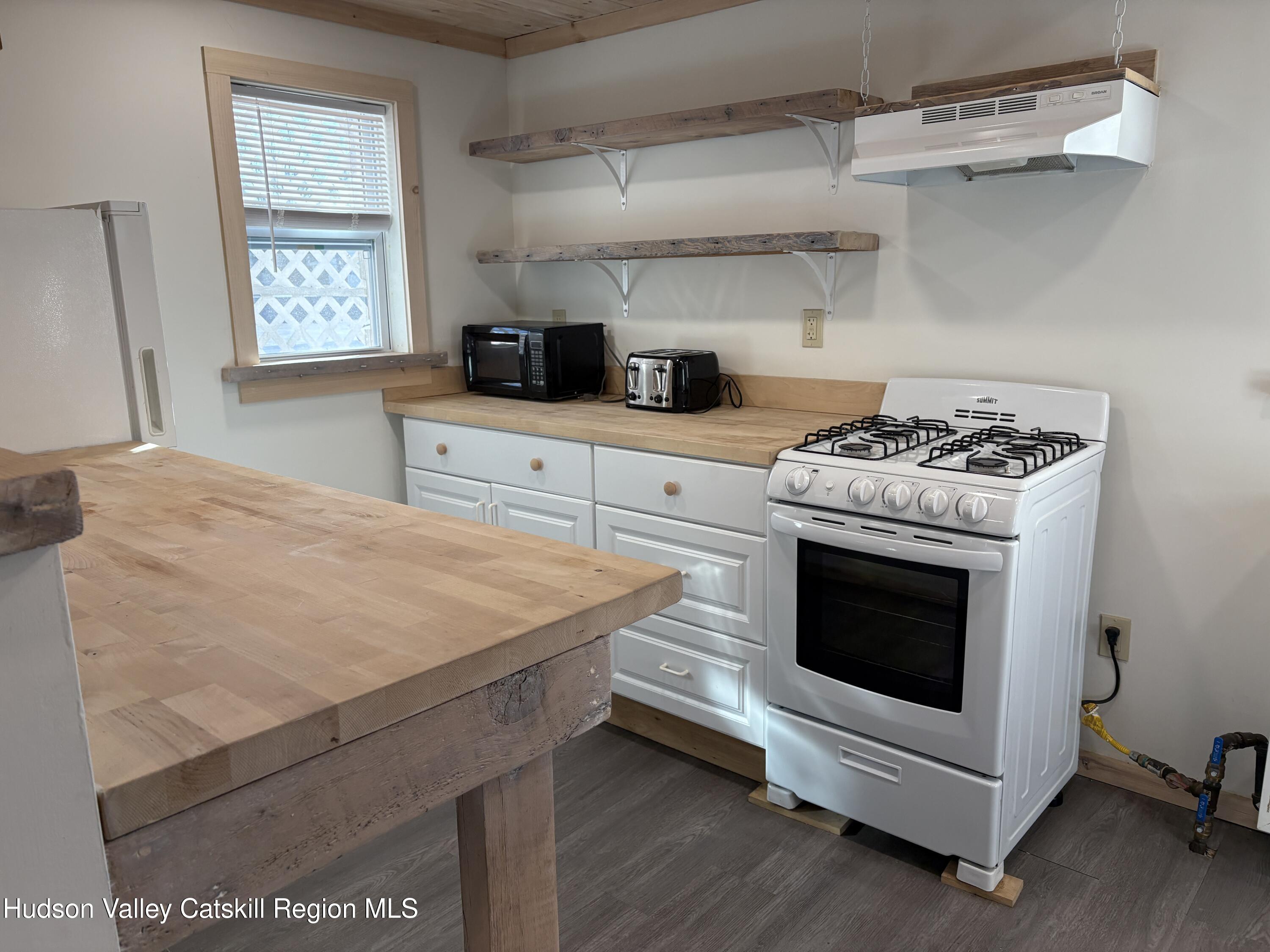 18 Market Street, Unit 2 Saugerties, NY 12477 - Photo 2 of 8 a kitchen with stainless steel appliances white cabinets and a stove
