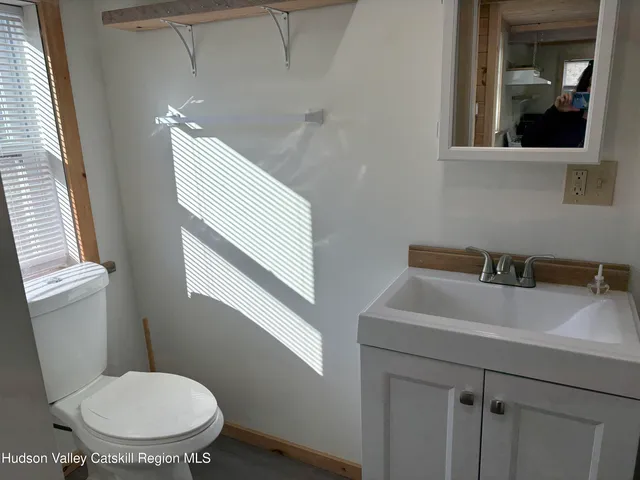 a bathroom with a toilet sink and mirror