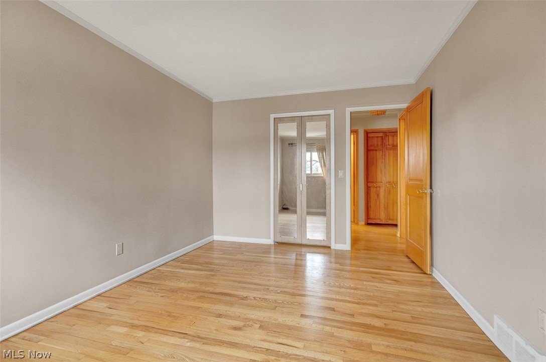 2990 Hampton Road Cleveland, OH 44120 - Photo 29 of 29 Unfurnished bedroom with light wood-style flooring, crown molding, and a closet