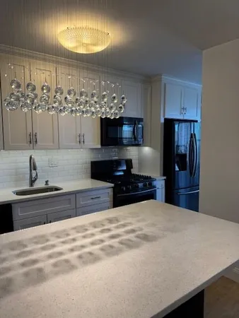 a large kitchen with kitchen island granite countertop a sink stainless steel appliances and cabinets