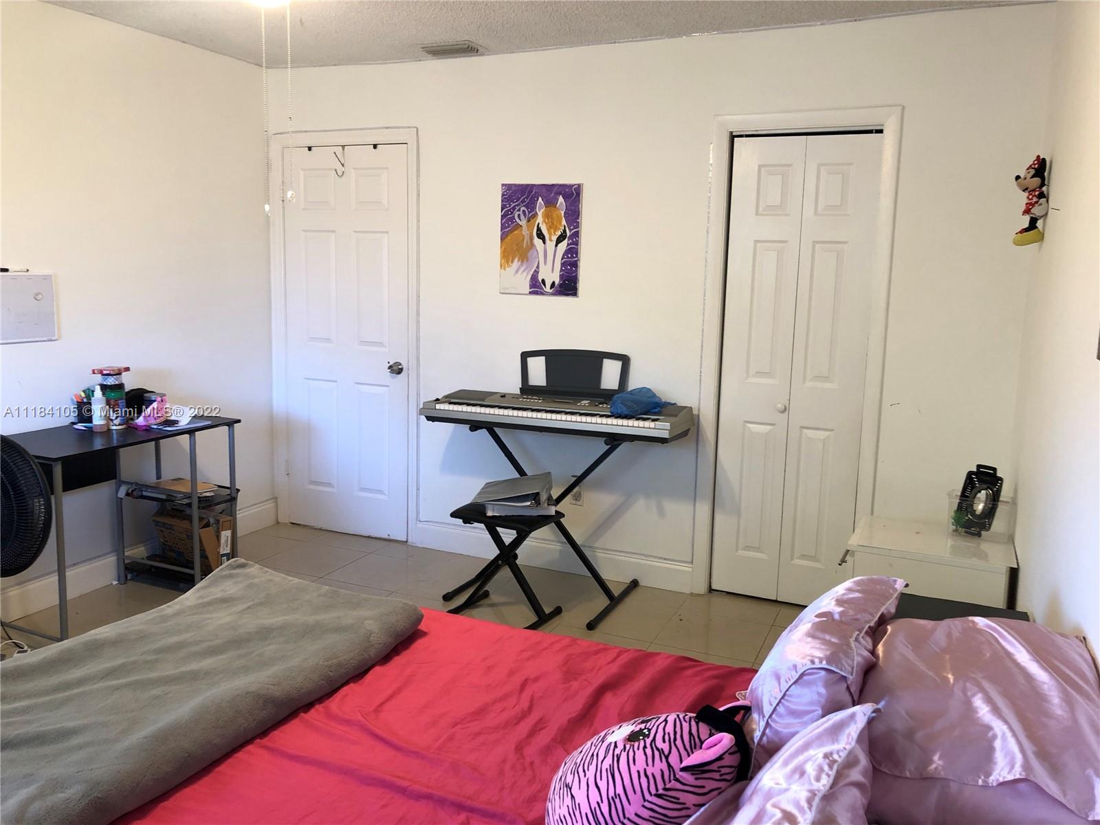 Kendall Miami, FL 33173 - Photo 13 of 26 a bedroom with a bed and a workspace