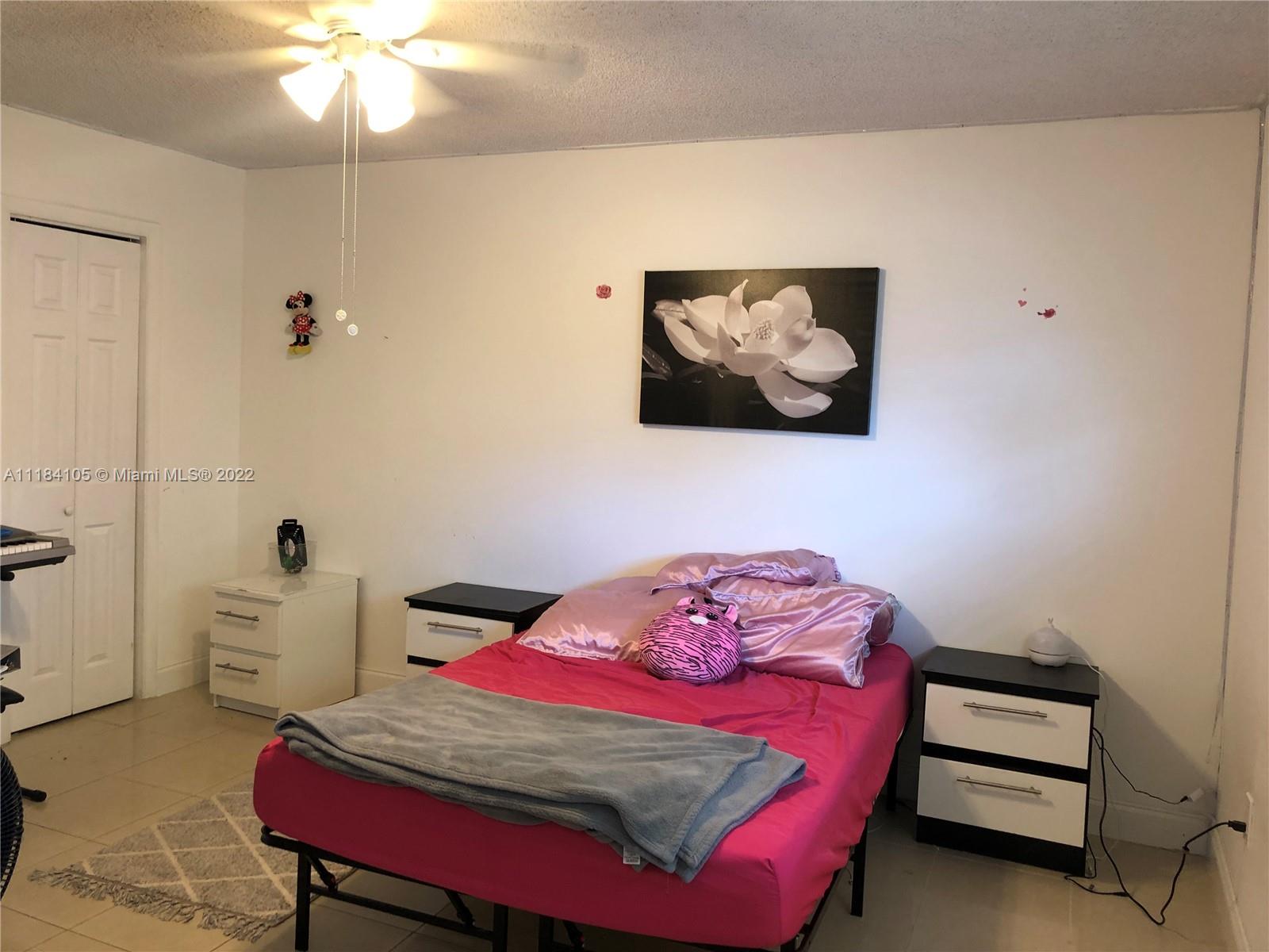 Kendall Miami, FL 33173 - Photo 14 of 26 a bedroom with a bed and a chandelier