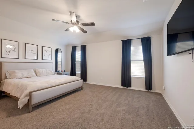 a spacious bedroom with a large bed and a chandelier