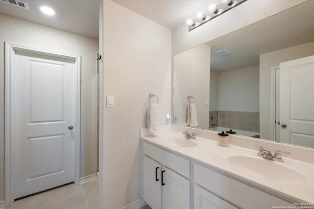 a bathroom with a double vanity sink and a mirror
