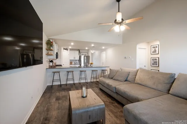 a living room with furniture and a dining table with kitchen view