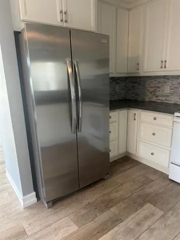 a kitchen with cabinets and a refrigerator