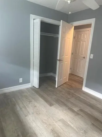 an empty room with wooden door and closet area
