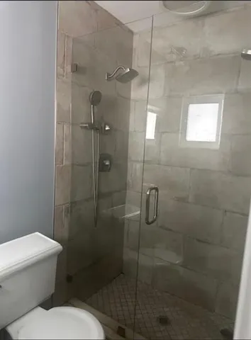 a bathroom with a toilet and a shower