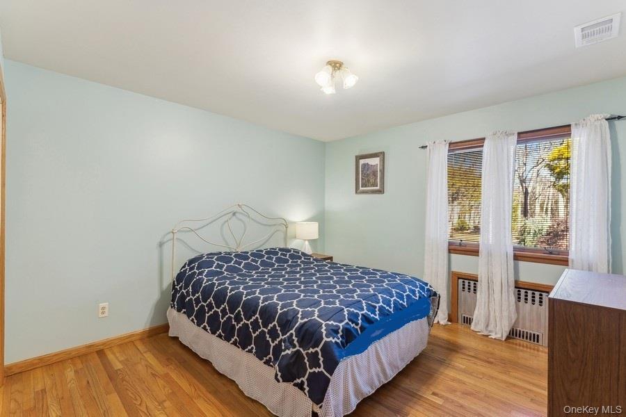 2905 Private Road East Marion, NY 11939 - Photo 21 of 33 Bedroom featuring radiator and light wood-type flooring