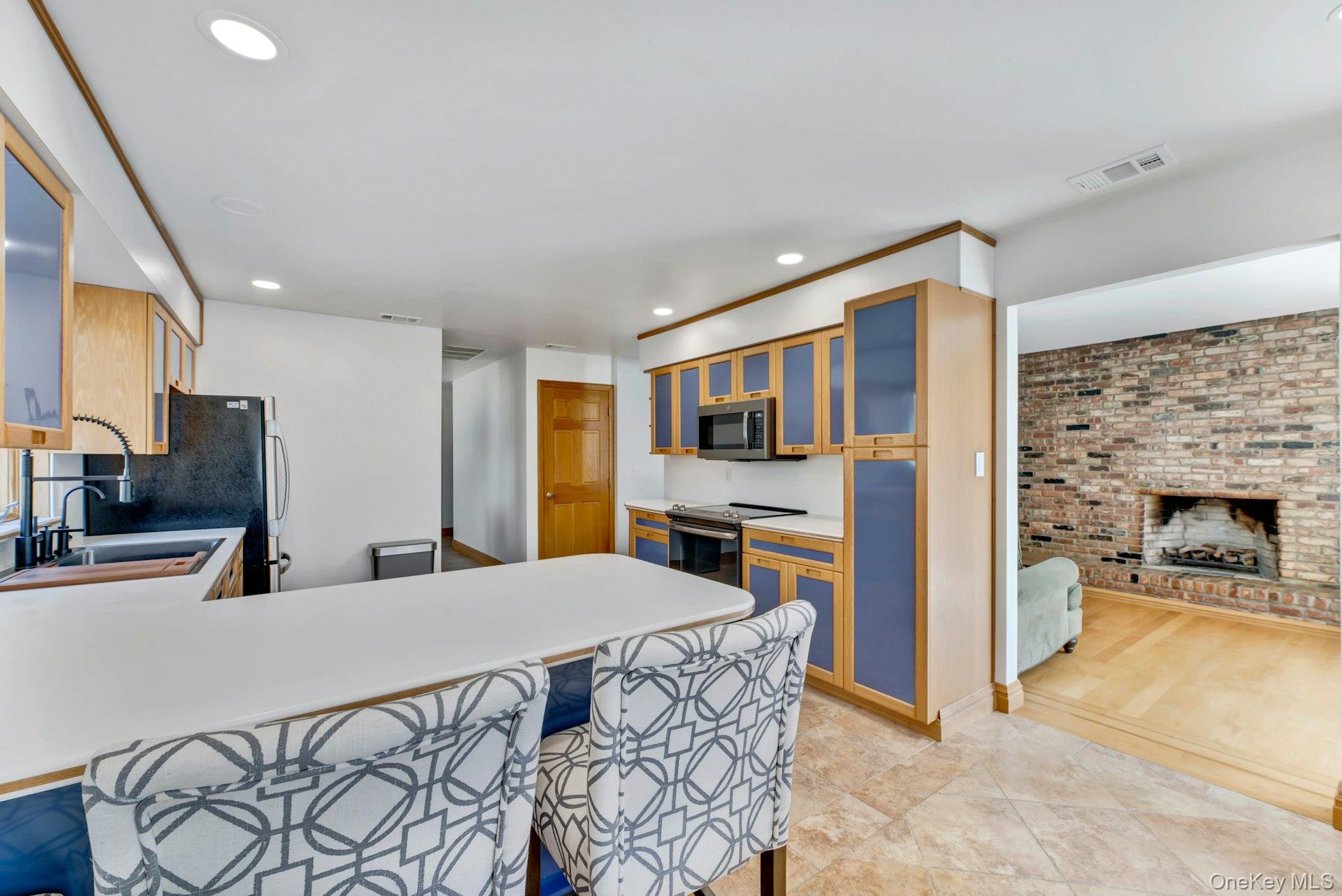 2905 Private Road East Marion, NY 11939 - Photo 8 of 33 Kitchen with visible vents, a breakfast bar area, appliances with stainless steel finishes, a fireplace, and a sink