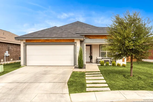a front view of a house with a yard and trees
