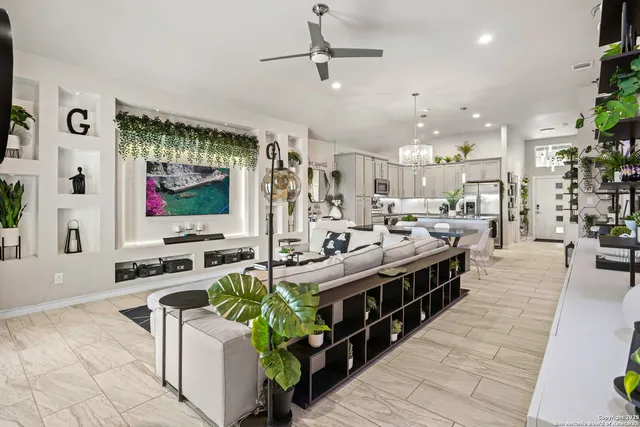 a large kitchen with stainless steel appliances a stove a sink dishwasher and a flat tv screen