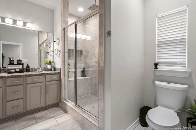 a bathroom with a shower sink mirror and toilet