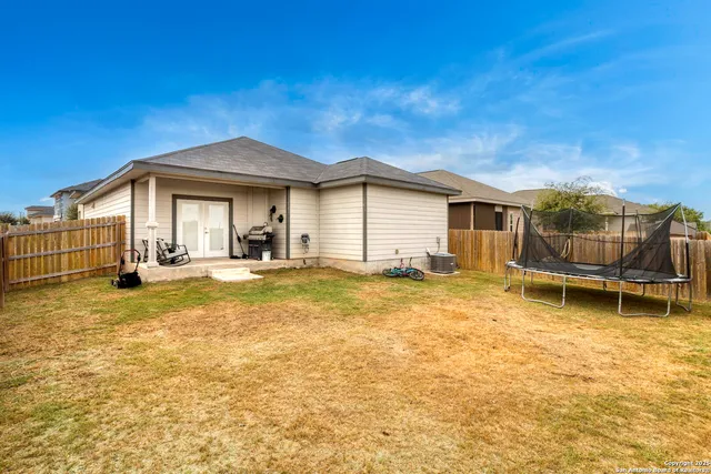 a backyard of a house with table and chairs