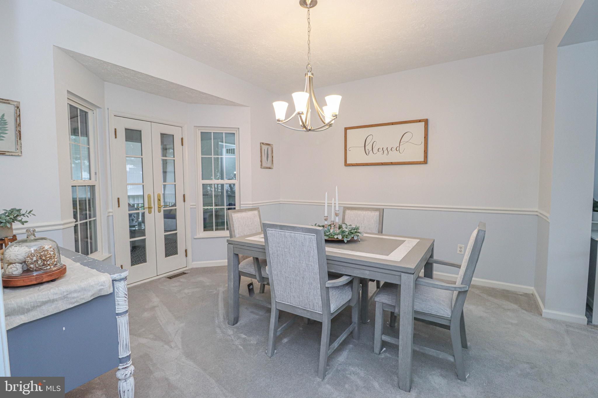 1724 Algonquin Road Frederick, MD 21701 - Photo 17 of 55 a view of a dining room with furniture wooden floor and a chandelier