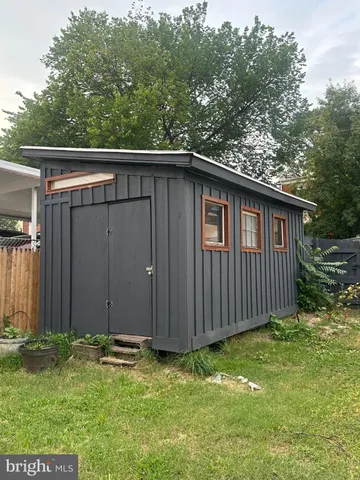 a backyard of a house with lawn chairs and wooden fence