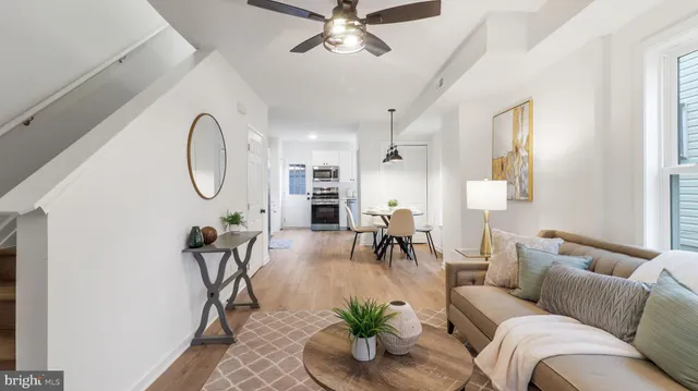 a living room with furniture a chandelier fan and a window