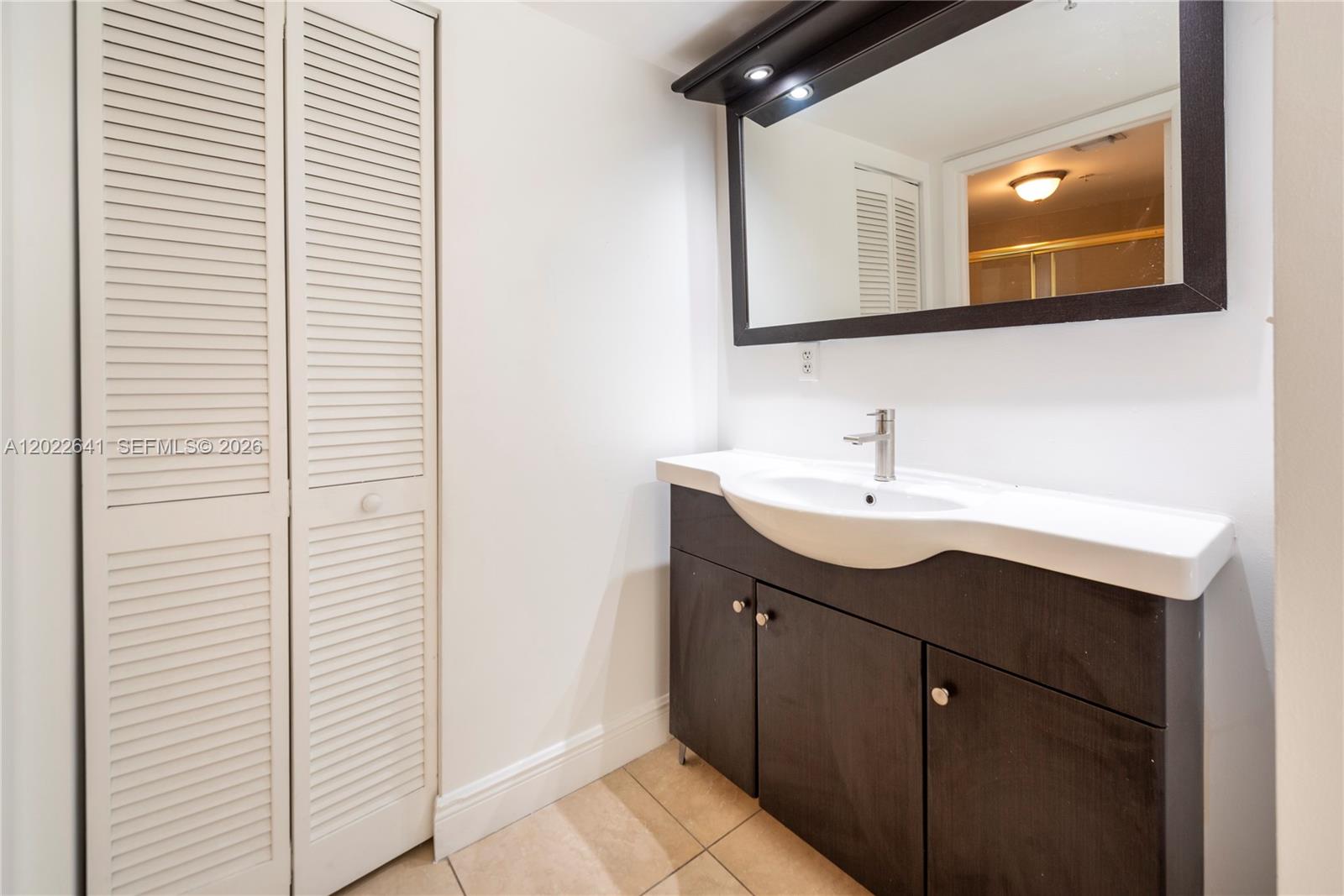 4147 Stirling Road, Unit 105 Dania Beach, FL 33314 - Photo 13 of 16 a bathroom with a sink and a mirror