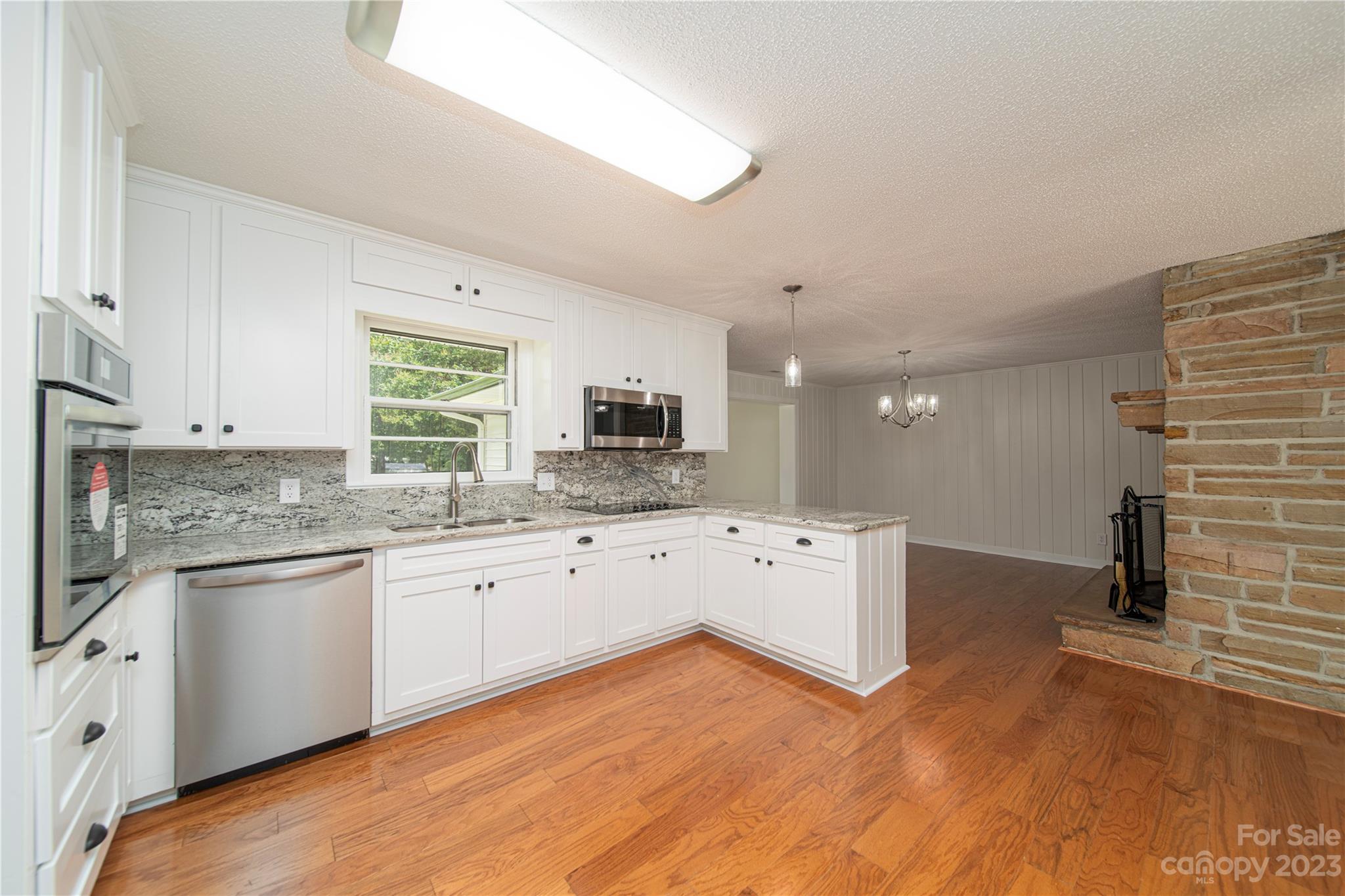 1253 Rainbow Road Advance, NC 27006 - Photo 23 of 46 a kitchen with granite countertop a sink and cabinets