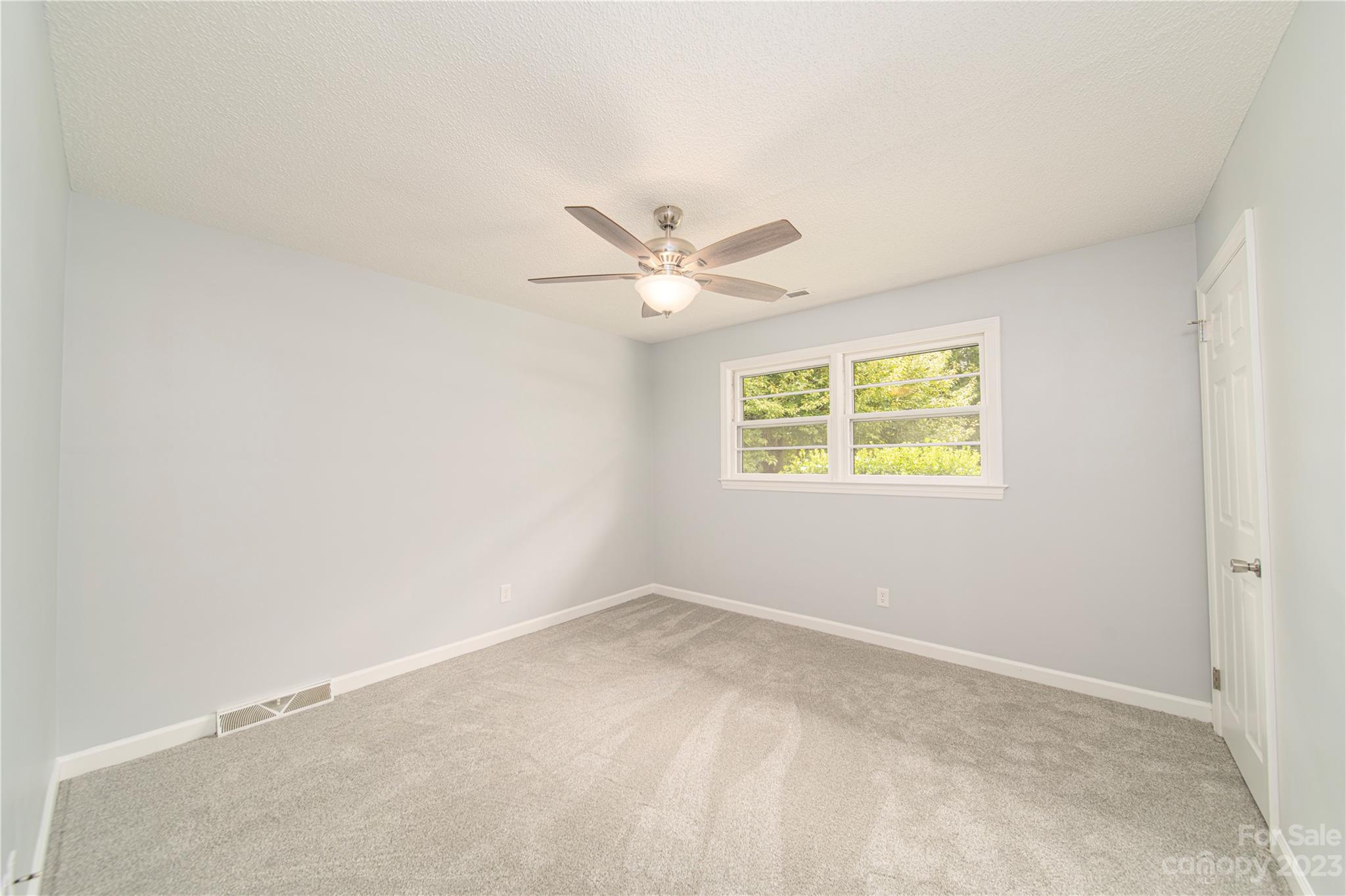 1253 Rainbow Road Advance, NC 27006 - Photo 37 of 46 an empty room with a window and a ceiling fan