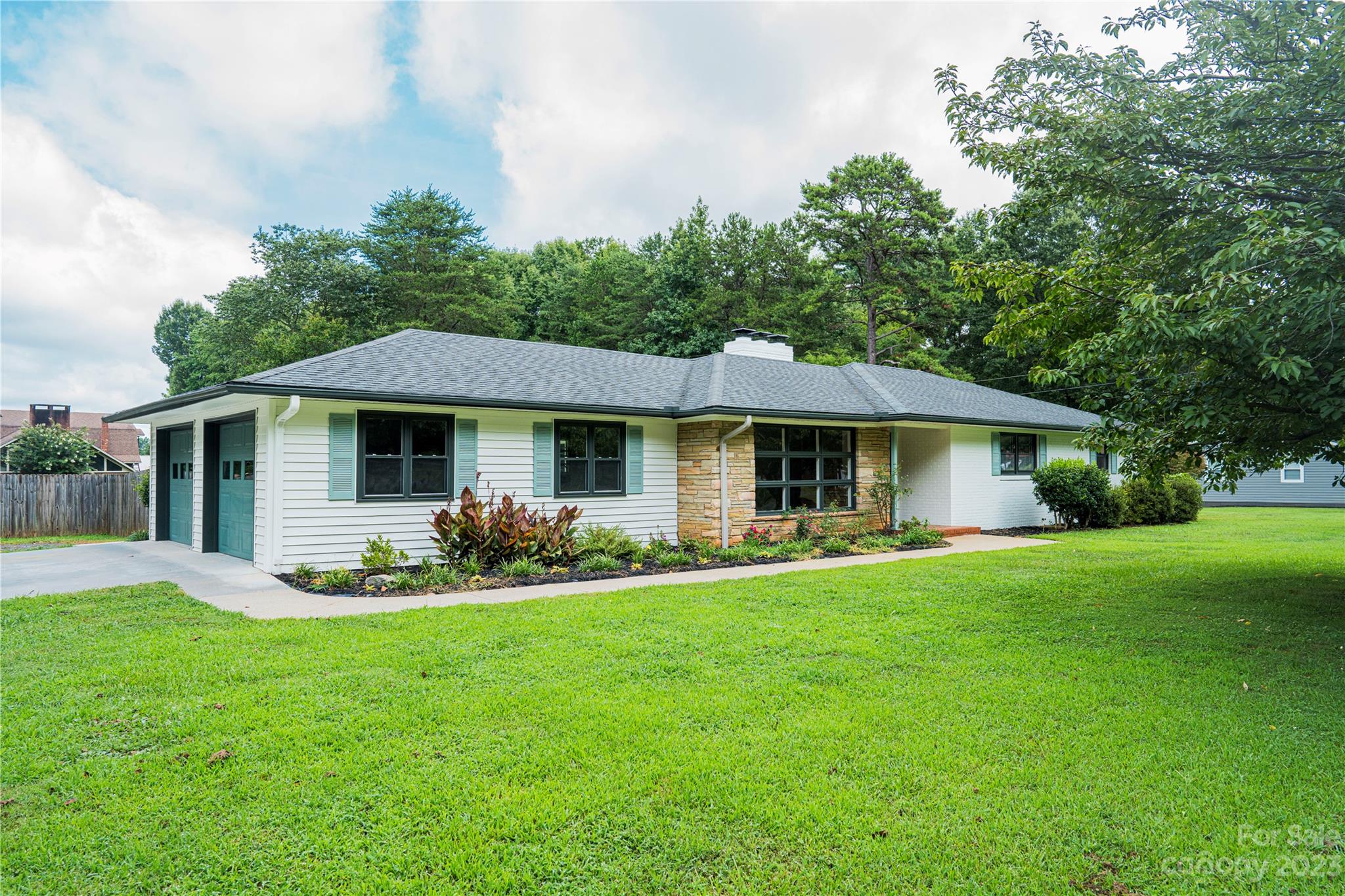 1253 Rainbow Road Advance, NC 27006 - Photo 8 of 46 a front view of a house with a garden and porch