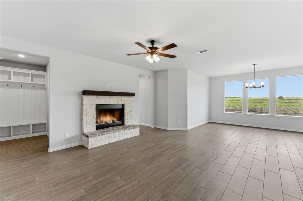 8911 County Road 623 Blue Ridge, TX 75424 - Photo 13 of 28 Unfurnished living room with a fireplace, ceiling fan, wood finish floors, and suspended lighting