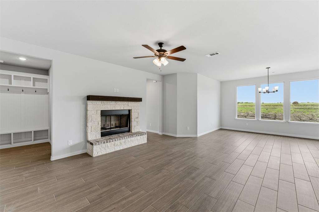 8911 County Road 623 Blue Ridge, TX 75424 - Photo 14 of 28 Unfurnished living room featuring a ceiling fan, wood finish floors, hanging lights, and a fireplace