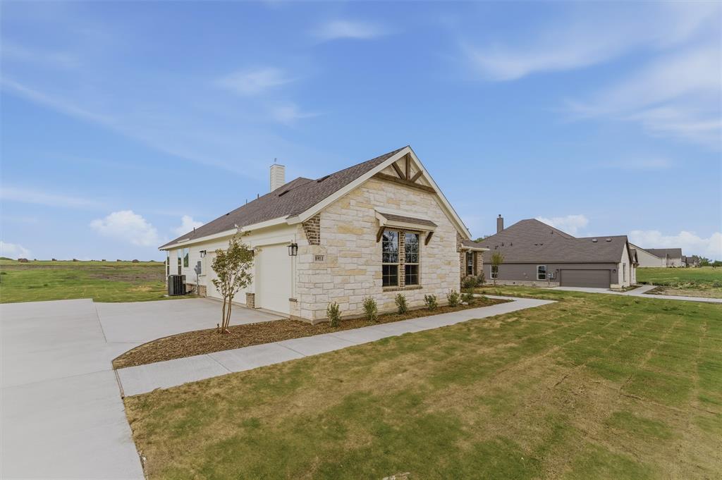 8911 County Road 623 Blue Ridge, TX 75424 - Photo 2 of 28 View of front of home with stone siding, a chimney, a front lawn, an attached garage, and concrete driveway