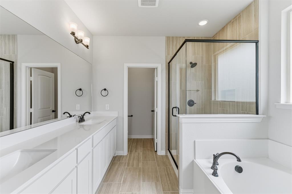 8911 County Road 623 Blue Ridge, TX 75424 - Photo 23 of 28 Full bath featuring double vanity, a stall shower, a bath, and wood tiled floors