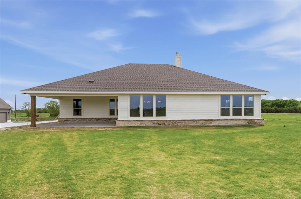 8911 County Road 623 Blue Ridge, TX 75424 - Photo 27 of 28 Back of house with brick siding, a yard, roof with shingles, a chimney, and a patio