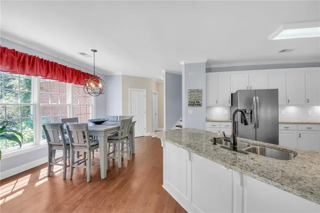a kitchen with granite countertop a sink a counter top space and stainless steel appliances