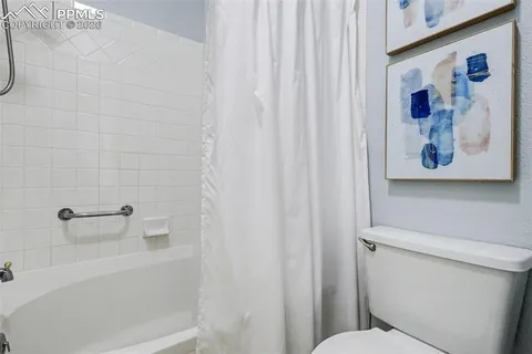 a bathroom with a toilet and a shower curtain