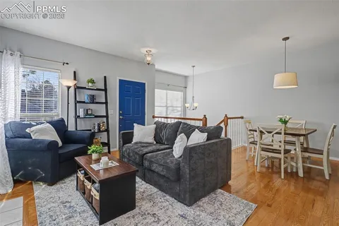 a living room with furniture a dining table and a floor to ceiling window