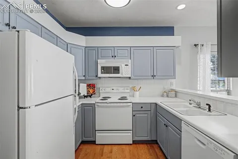 a kitchen with a sink a refrigerator a microwave and cabinets