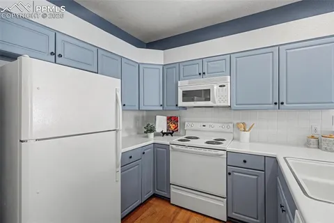 a white refrigerator freezer sitting in a kitchen with white cabinets