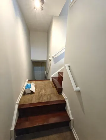 a bed sitting in a bedroom next to a window with kitchen