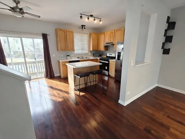 a kitchen with stainless steel appliances granite countertop a refrigerator a sink dishwasher a stove and white countertops with wooden floor