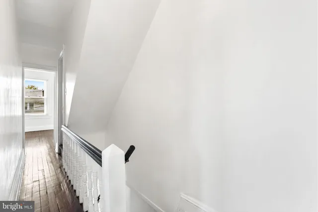 a view of a hallway with wooden floor and staircase