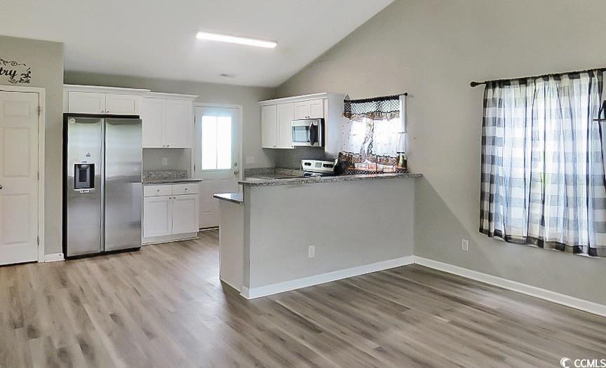 204 Rosedale Drive Aynor, SC 29511 - Photo 5 of 23 Kitchen featuring appliances with stainless steel finishes, white cabinets, lofted ceiling, light wood-style flooring, and a peninsula