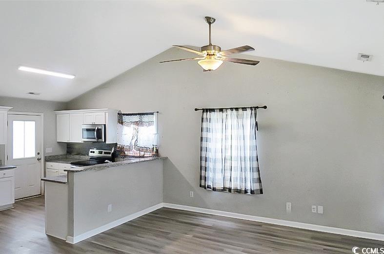204 Rosedale Drive Aynor, SC 29511 - Photo 6 of 23 Kitchen featuring white cabinetry, appliances with stainless steel finishes, wood finished floors, a ceiling fan, and high vaulted ceiling