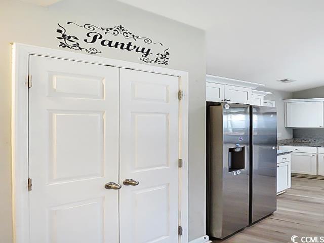 204 Rosedale Drive Aynor, SC 29511 - Photo 9 of 23 Kitchen with stainless steel fridge with ice dispenser, white cabinets, and light wood-style floors