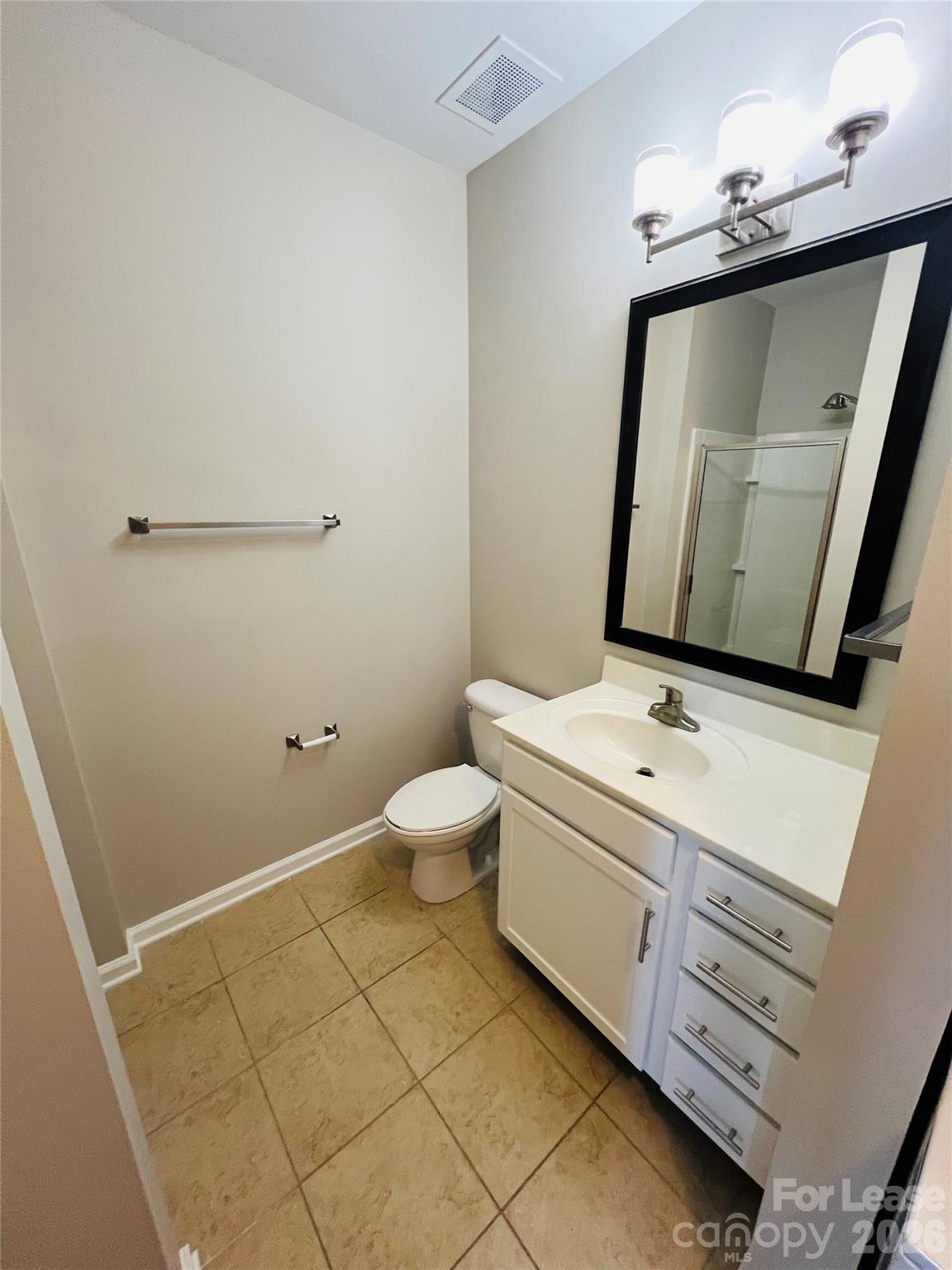 4310 Park Road, Unit 207 Charlotte, NC 28209 - Photo 8 of 9 a bathroom with a sink a toilet and mirror