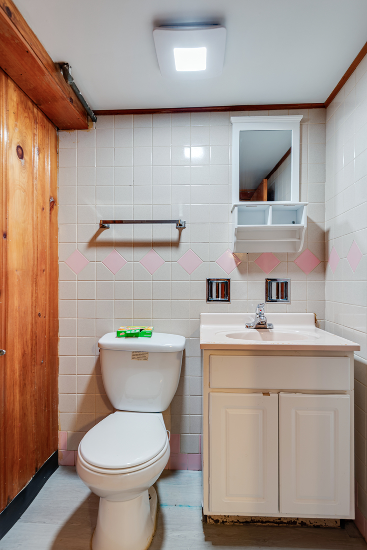 7004 West Foster Avenue Chicago, IL 60656 - Photo 11 of 16 a bathroom with a toilet sink and mirror