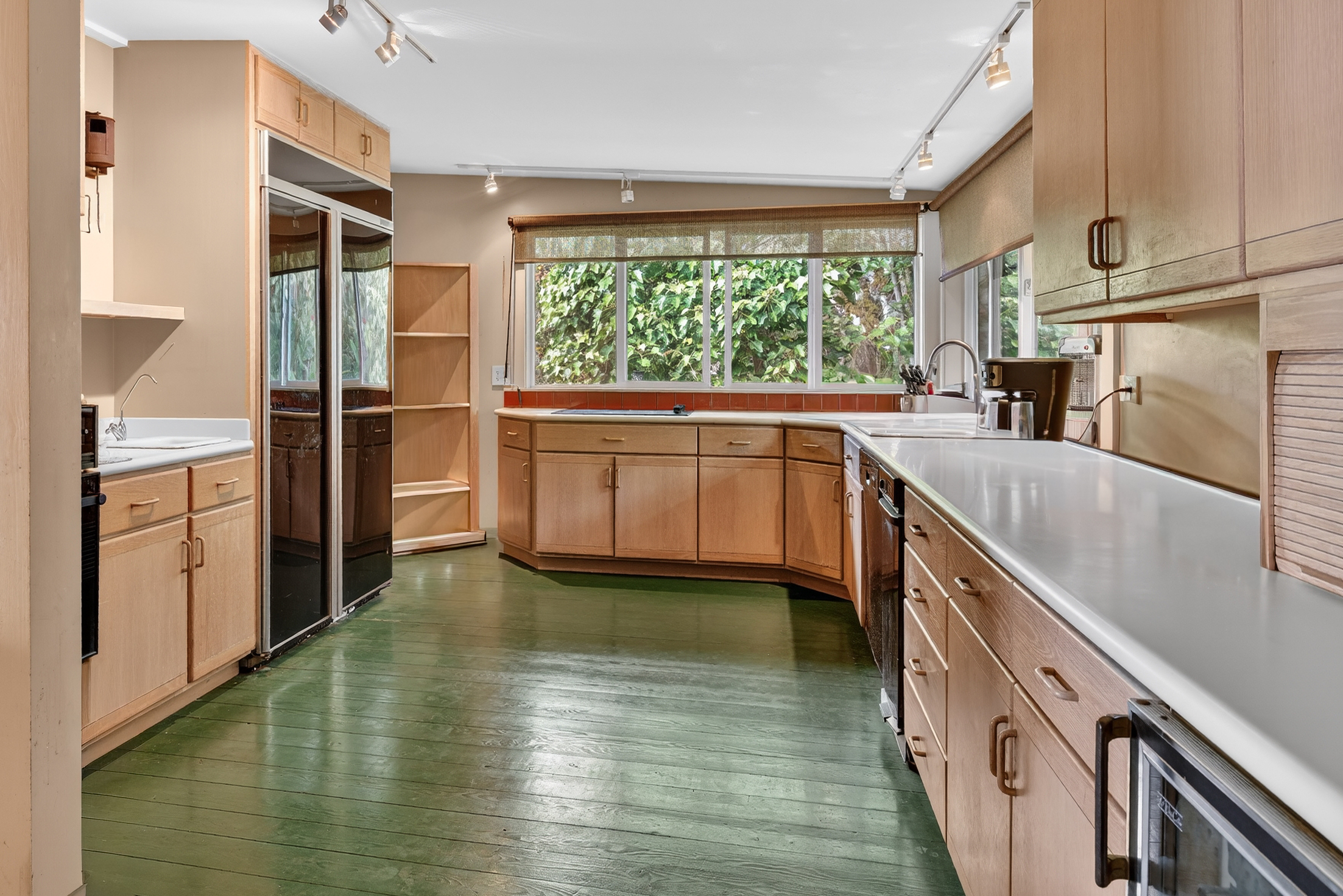 a kitchen with stainless steel appliances granite countertop a refrigerator a sink dishwasher a stove and white countertops with wooden floor